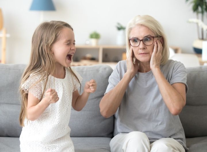 child screams while grandmother blocks ears